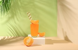 Modern still life with citrus fruits, orange juice and oranges on a pastel background with long hard shadows, minimal detox diet concept, summer vitamin drinks, selective focus,