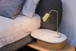 Gold brass lamp on bedside table decor in the interior.