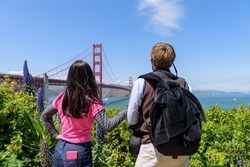 A couple admiring a beautiful view  of San Francisco's Golden Gate Bridge