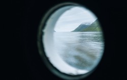 View of the sea from a round ship window. Ferry window Faroe islands Klaksvik route on Kalsoy Island. Travel concept