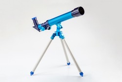 Blue toy telescope on a tripod, single object isolated on white background. Stargazing, space observation science instruments, tools for young kids, children, astronomy hobby conceptual symbol, nobody