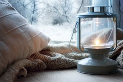 lantern and pillows on windowsill with winter view