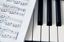 close-up music score on piano keyboard