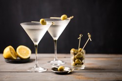 Martini cocktail on wooden worktop. Olive garnish. Space for text