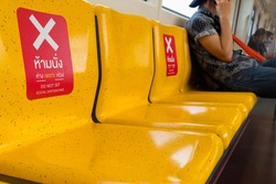 Seat in subway distance for one seat from other people keep distance protect from COVID-19 viruses, social distancing for infection risk, Thai language translate do not sit, Away because of worry.