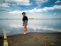 A boy looking at a flooded street