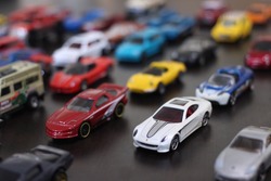 colorful toy car collection on wooden table in natural light. selective focus