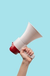 Megaphone in woman hands on a white background.  Copy space. 