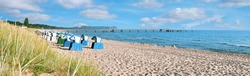Sandy beach and traditional wooden beach chairs on island Rugen, Northern Germany, on the coast of Baltic Sea. Panorama image