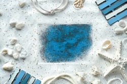 Sand frame, seashells, starfish, cord.Monochromatic off white and turquoise blue flat lay, copy-space. Frame for summer greeting text.