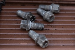 Some used wheel bolts lying around while the brakes are being fixed.