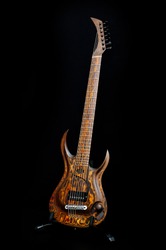 Seven-string electric guitar made of dark wood. Background for music and creativity.