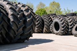 Big machines tires stack background. Industrial tires outside for sale
