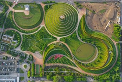 Aerial view of Parco del Portello in Milan, near CityLife, Lombardia. View from the height of park with a green lawn and paths. Abstract design similar to a dragon. Drone photography in Milano.