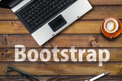 Bootstrap CSS framework . Word Bootstrap on wooden desk and laptop 