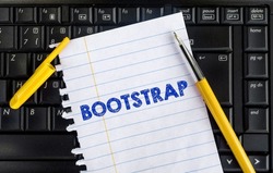 Word Bootstrap on paper and laptop. Bootstrap CSS framework
