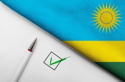 pencil, flag of Rwanda and check mark on paper sheet 