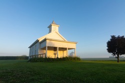 Old schoolhouse in the Midwest as the morning sun clears the light fog.  Tiskilwa, Illinois, USA