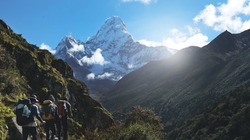 Three Trekkers Walking on Everest Highway While Seeing Mount Ama Dablam, Everest Base Camp Trek From Tengboche to Dingboche , Nepal