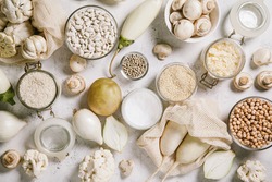 White vegetables and mushrooms, rice, quinoa, legumes, white peppercorns, coconut oil on a white background. Healthy eating and the concept of clean eating. Flat lay, top view, copy space.