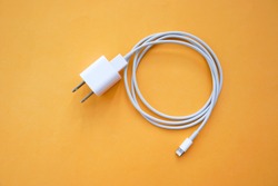 Mobile Phone Charger on Orange Background Top View