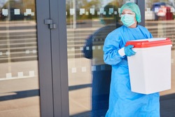 Doctor or surgeon with organ transport after organ donation for surgery in front of the clinic in protective clothing