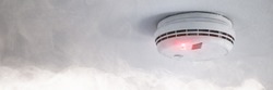 Smoke detector on the ceiling in case of fire alarm due to smoke as fire protection warning