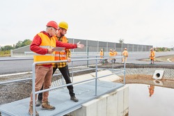 Site manager and construction worker inspecting a construction on a road construction site