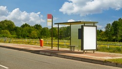Empty bus stop with bus shelter and advertising poster template mock-up in summer