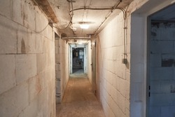 Hallway in the basement leads to the boiler room and drying room from the house