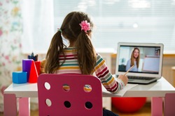 Young female distance teacher having video conference call with pupil using webcam. Online education and e-learning concept. Home quarantine distance learning and working from home.