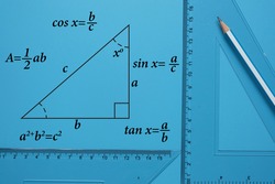 A picture of pencil, set square and right angle triangle drawing with formula on blue background. Geometry and trigonometry concept