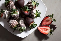 group of chocolate covered strawberries on white plate and light background, sliced chocolate covered strawberry, valentines day dessert, romantic, food gift