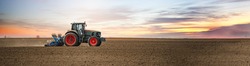 Panoramic landscape view of the tractor on the field sowing. Planting seeds mechanization.