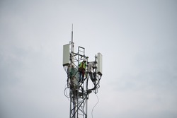Engineer maintenance on telecommunication tower doing ordinary maintenance control to an antenna for communication,  4G and 5G cellular. Cell Site Base Station.