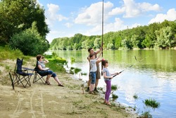family camping and fishing, people active in nature, child caught fish on bait, river and forest, summer season