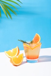 Orange punch cocktail cold and refreshing with orange slice on color background. summer drink.
