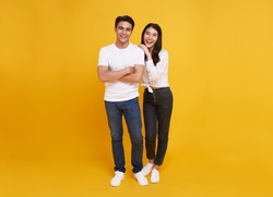 Young attractive Asian couple man and woman happy and hugging on yellow background. Concept for love photography.