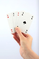 Four aces playing cards in woman's hand on white background