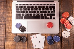 Online betting or poker. Top view of a computer with chips and cards for betting or playing. Online game concept.