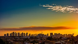 Ribeirao Preto city at sunset - Sao Paulo, Brazil. Buildings located on the avenue Joao Fiusa in Ribeirao Preto on the horizon at sunset with blue sky with some clouds.