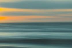 Abstract seascape with blurred panning motion. Image displays blue, yellow, and light turquoise split-toned color scheme.
