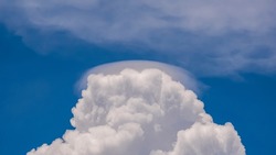 Pileus cloud on white Cumulonimbus Congestus cloud in blue sky background