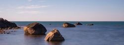 Panoramic Tranquil Zen-like Seascape with ancient rocks on the calm beach