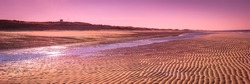 Pink sunset over the coastal horizon. Tropical seascape with the view of undulating rippled sand bar and small river on the beach at low tide in Cape Cod Bay, Massachusetts