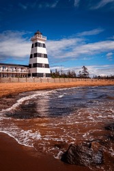 West Point Lighthouse and high tide rolling in on the cove at Gulf of St Lawrence, O'Leary, Prince Edward Island, Canada