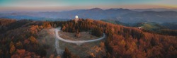 Aerial drone panorama view of a rain radar or meteorological doppler radar for measuring precipitation in early morning hours during sunrise on Pasja Ravan hill in Slovenia