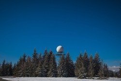 Doppler rain or weather radar on the top of the hill called Pasja Ravan in Slovenia on cold winter day. Beautiful sunny day and rain radar in between.