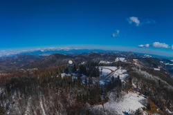 Wide panorama of doppler rain or weather radar on the top of the hill called Pasja Ravan in Slovenia on cold winter day. Beautiful sunny day and rain radar in between.