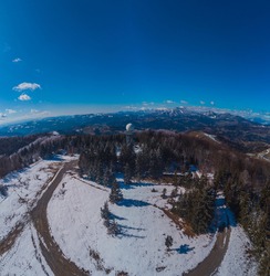 Wide panorama of doppler rain or weather radar on the top of the hill called Pasja Ravan in Slovenia on cold winter day. Beautiful sunny day and rain radar in between.